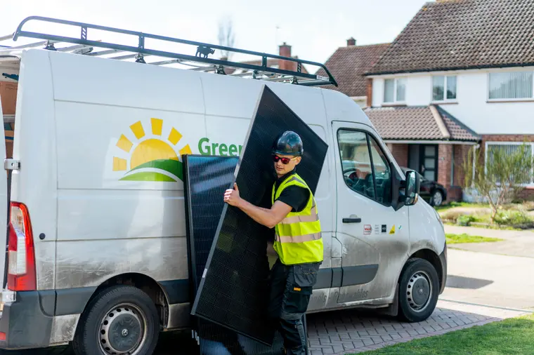 Installer unloading a solar panel from a Greenscape van
