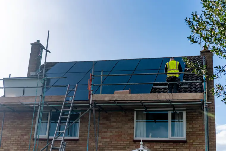 Solar array being installed on a scaffolded roof
