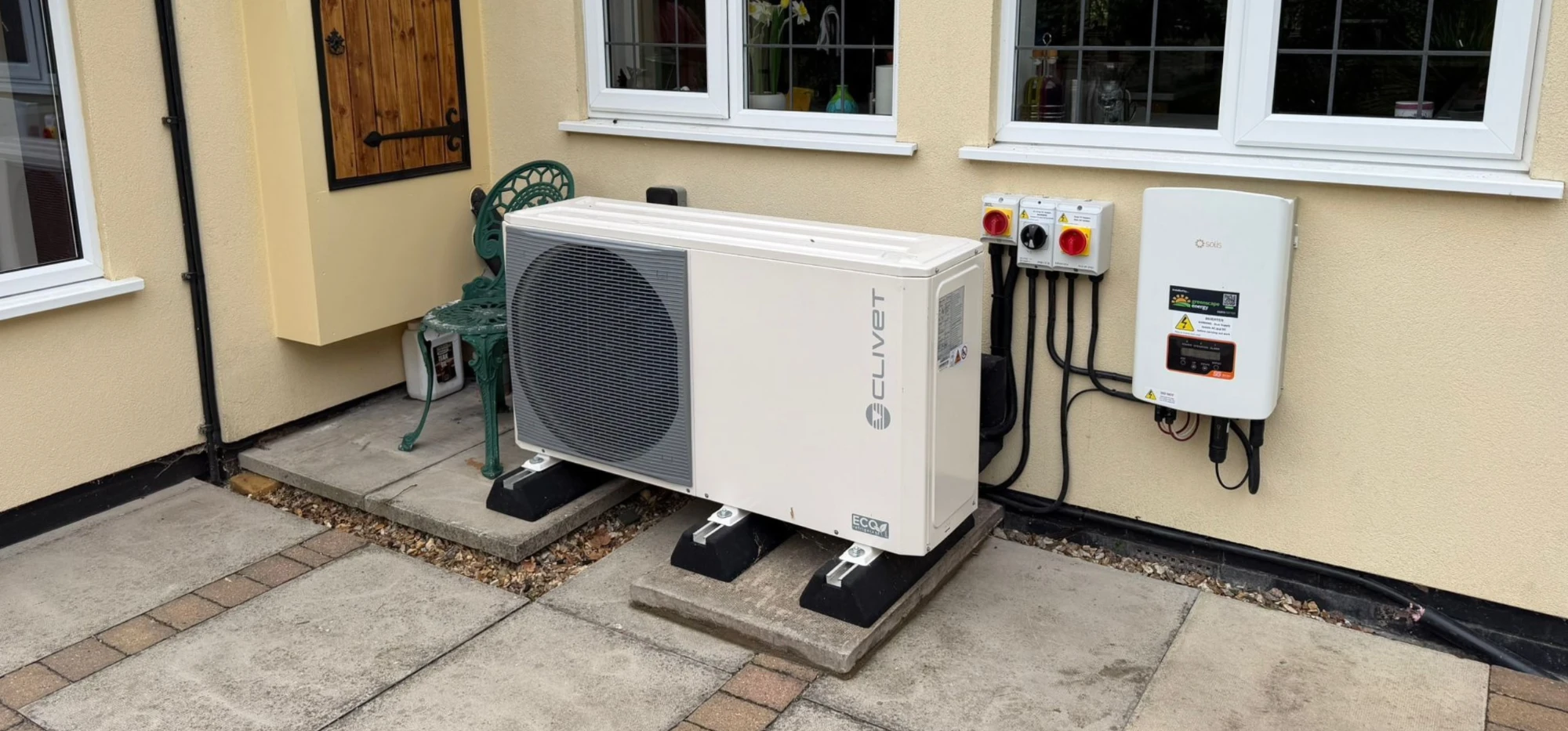 A Clivet heat pump and Solis inverter installed beside a house