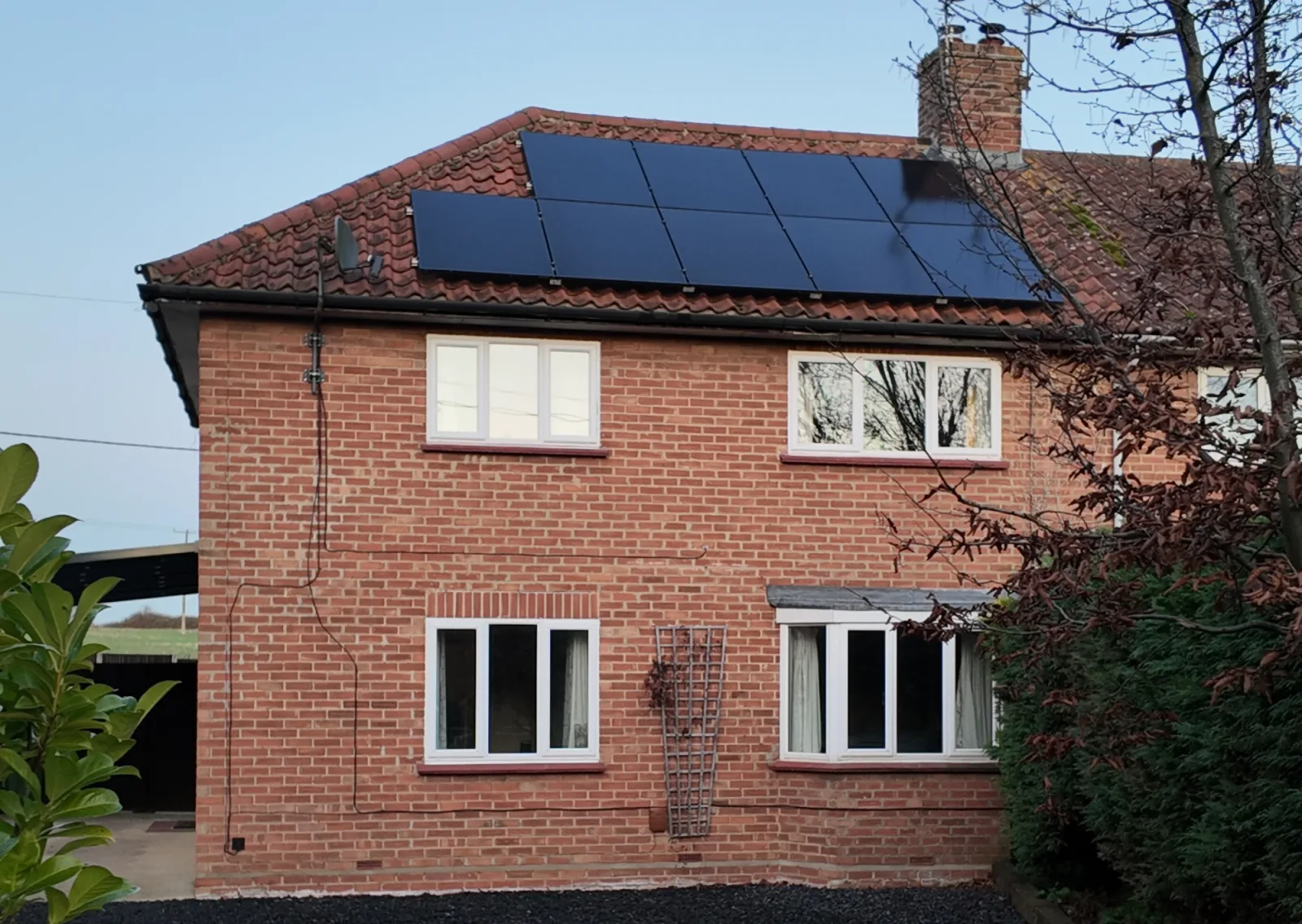 Louise's red brick home with black solar panels on the roof