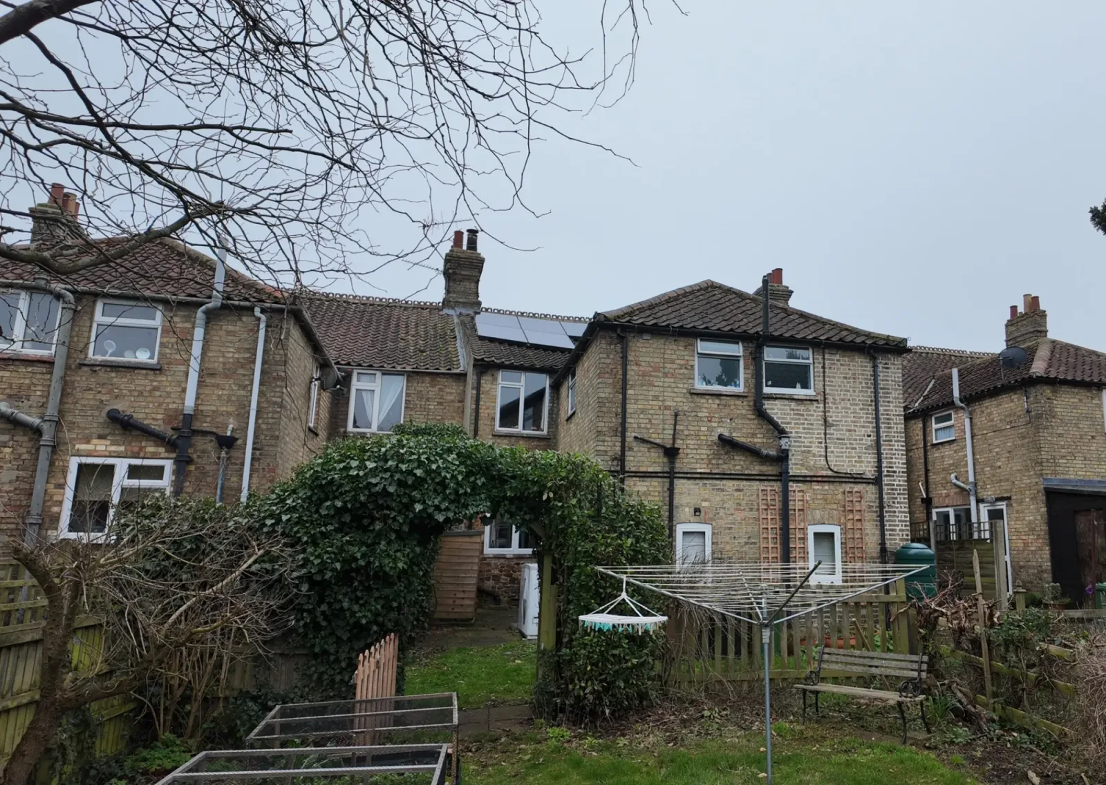 Rear of Alistair's 1903 brick terraced house with black solar panels on the roof
