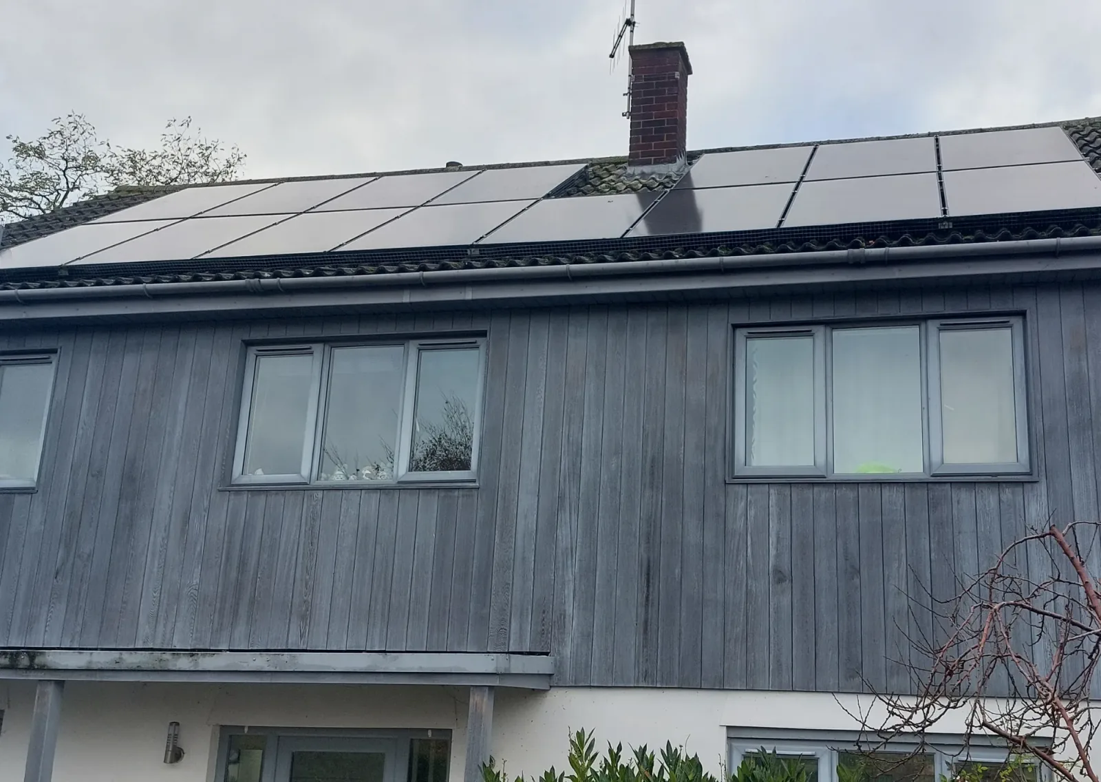 Michael's home with black solar panels and pigeon proofing along the roof edge