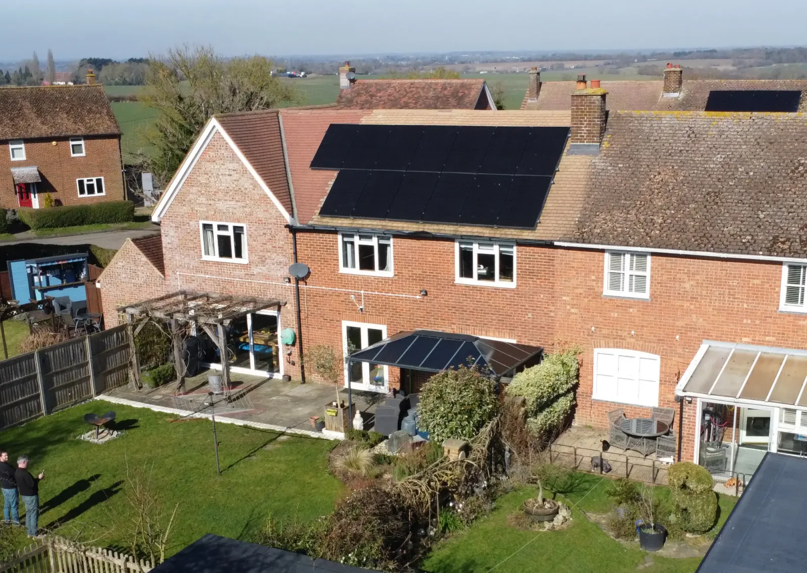 Aerial view of Chris's brick terrace with a large array of black solar panels