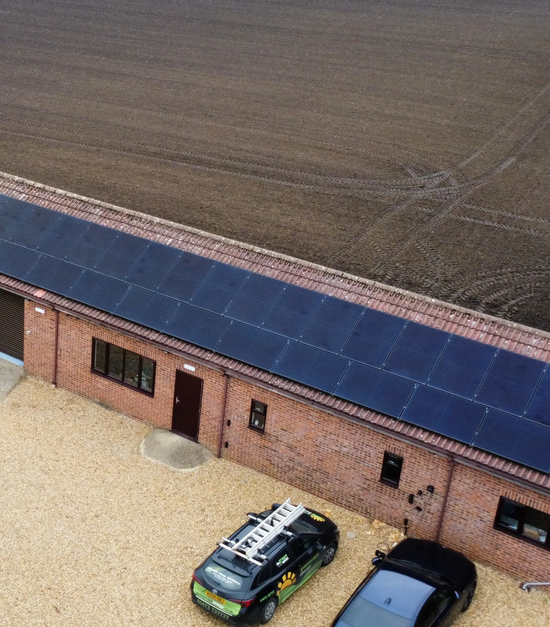 A farm building with solar panels across its roof