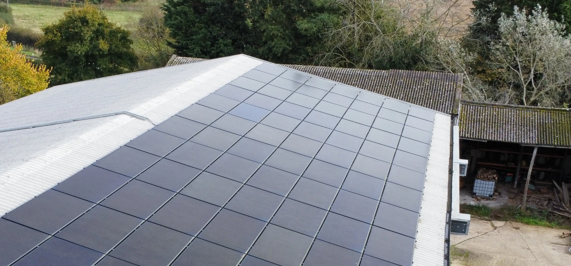 A farm building with roller doors and a roof of solar panels