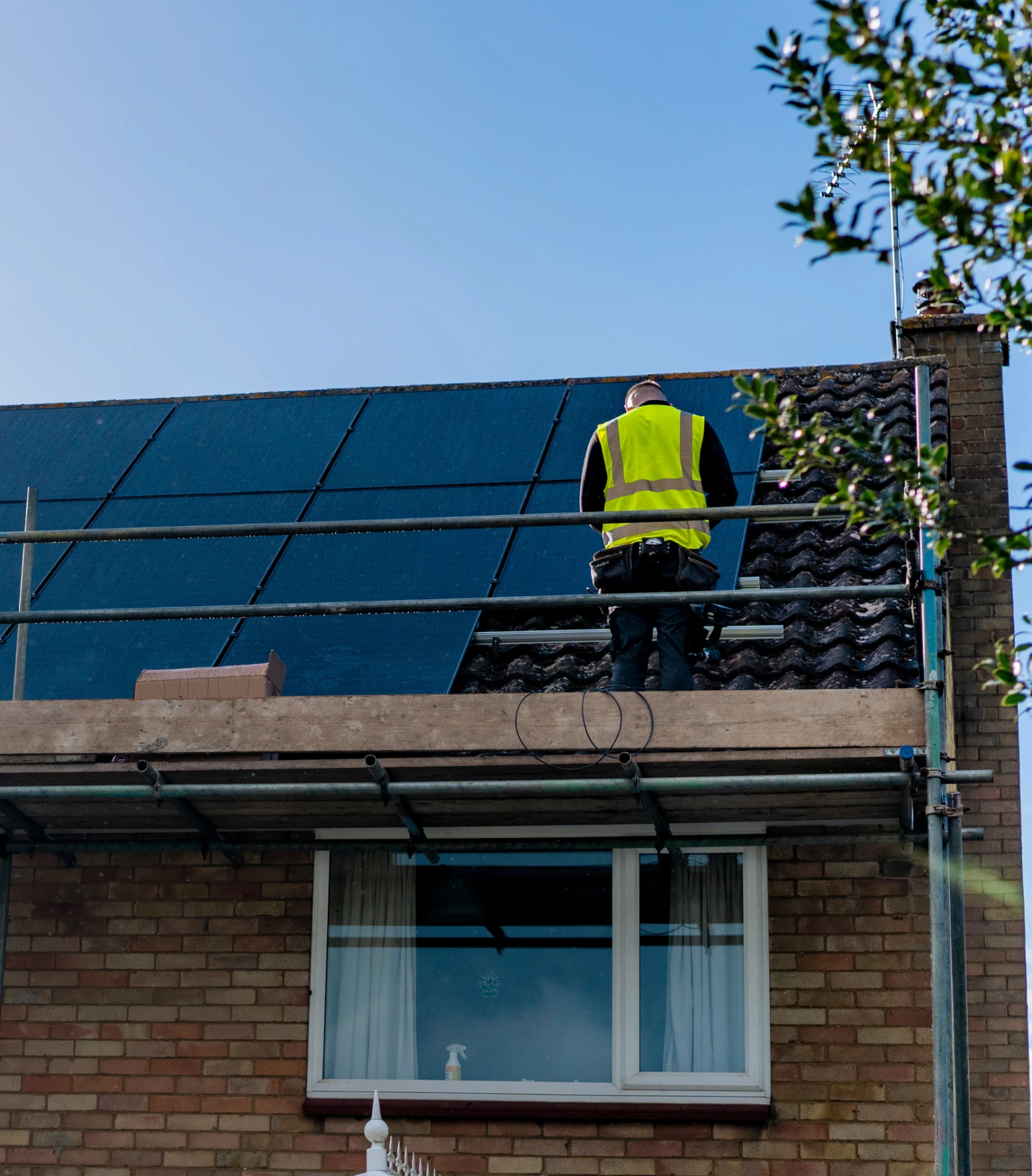 A home battery storage unit mounted on an exterior brick wall