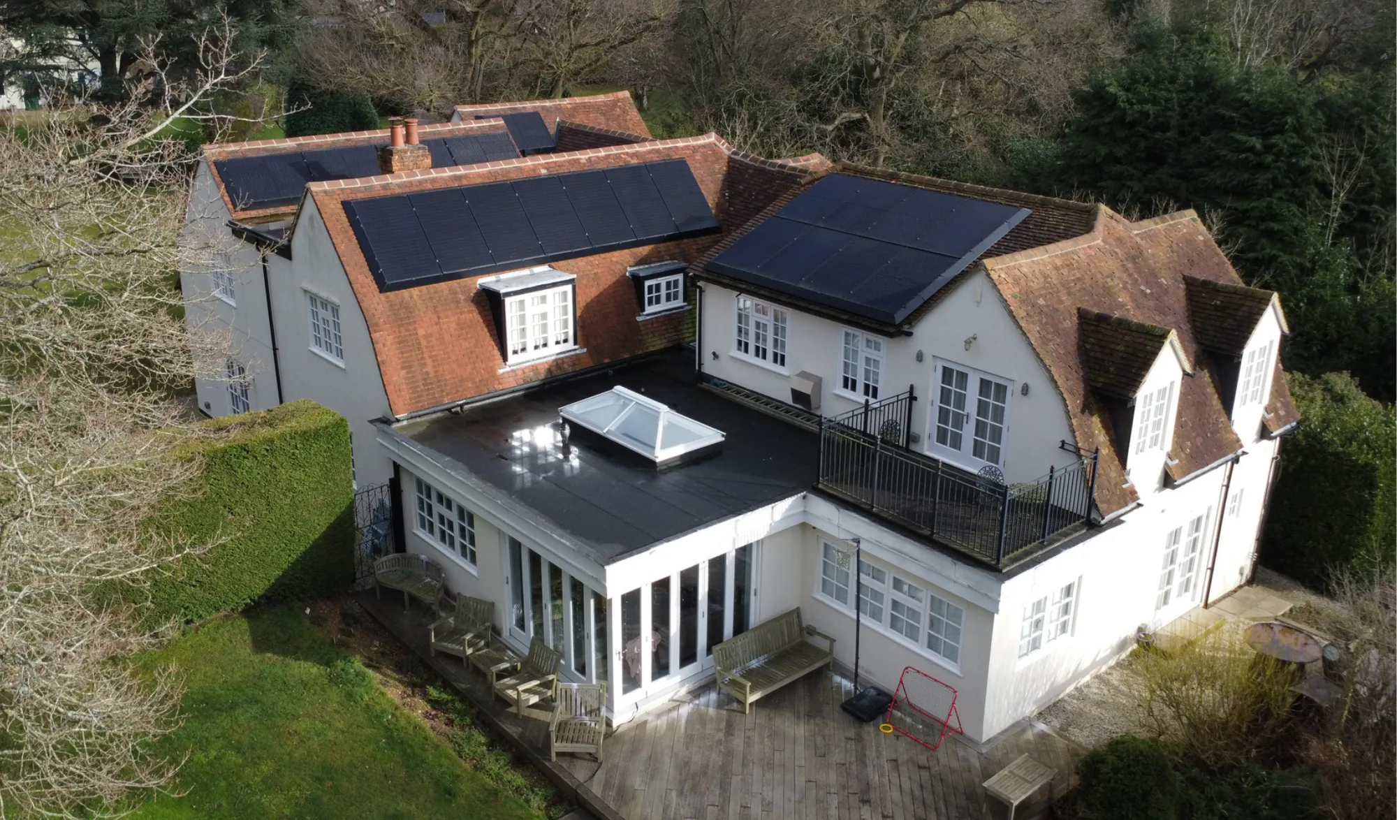 Two Greenscape installers fitting a panel to a tiled roof