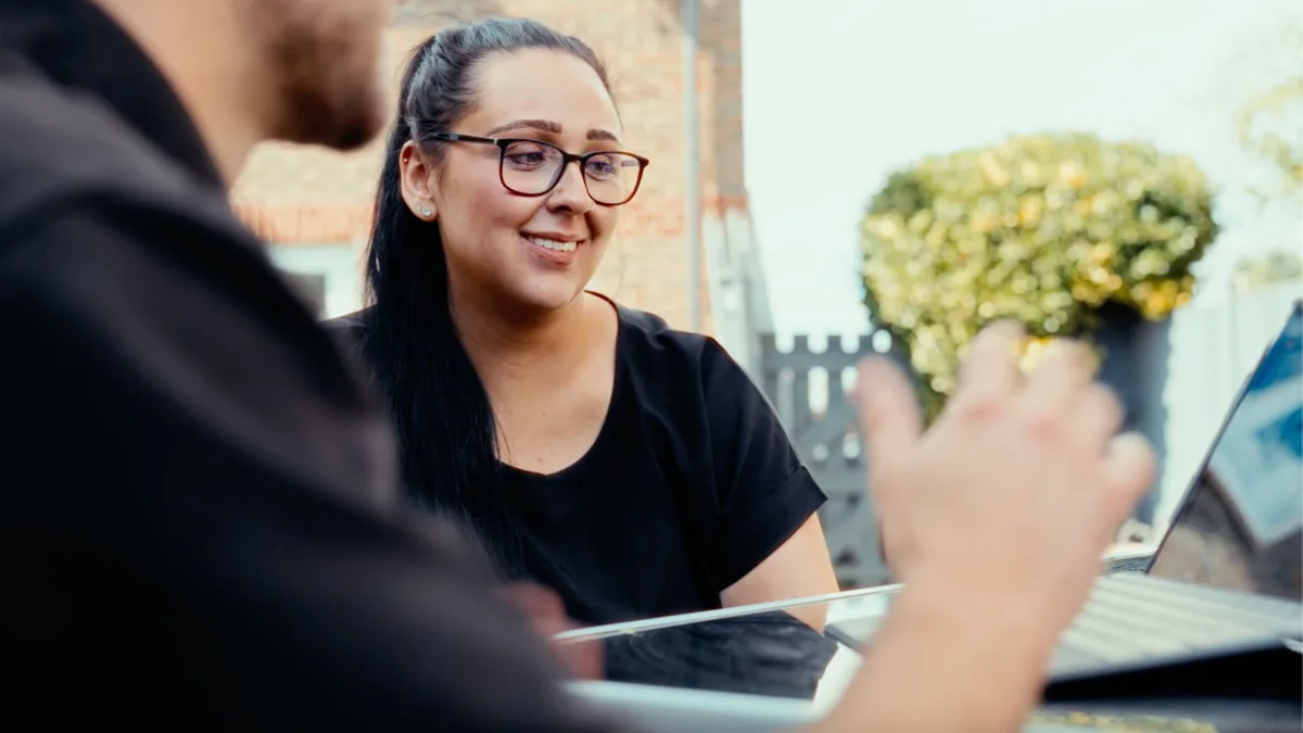 A Greenscape adviser talking a customer through a proposal on a laptop