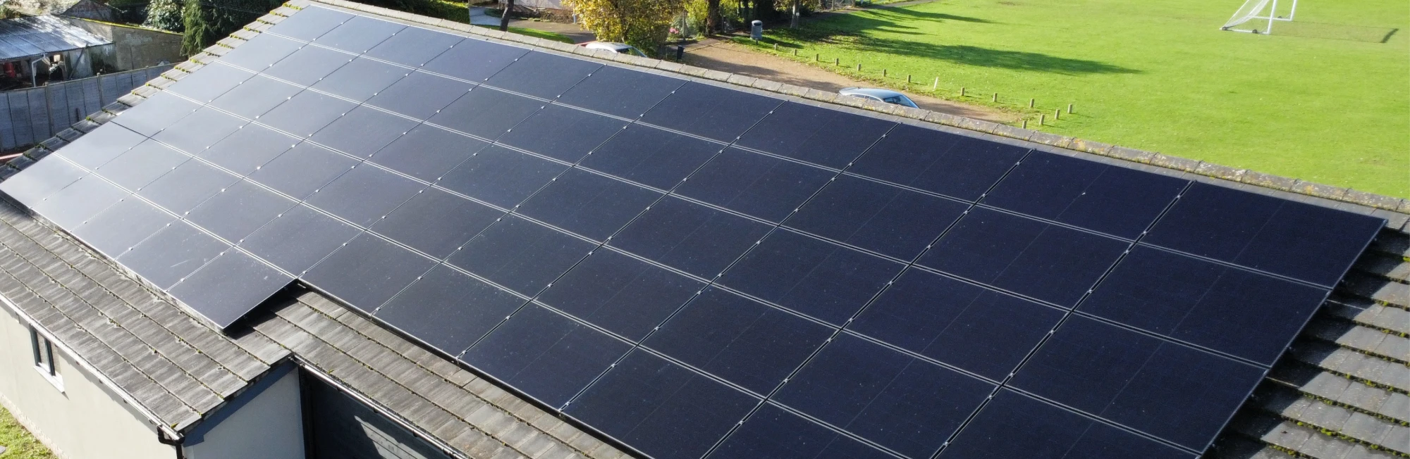 A large warehouse roof with a block of solar panels
