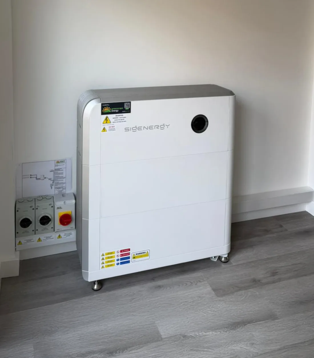 A Sigenergy battery in a room beside three isolators